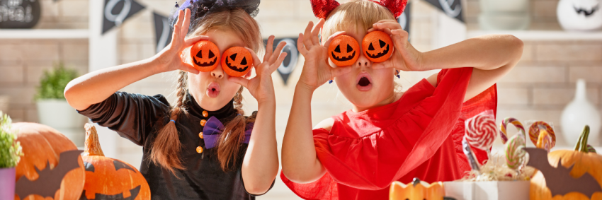 two children being silly with Halloween decorations 