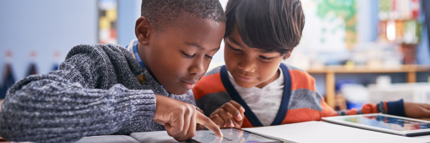 children working on tablets in a class setting