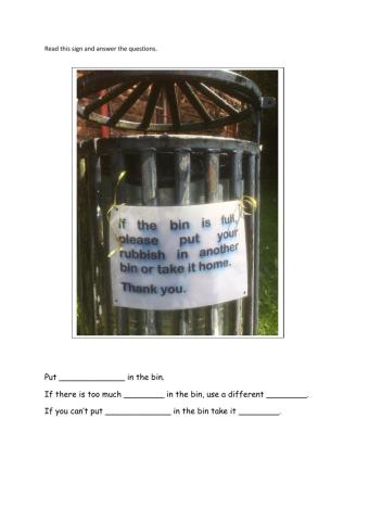 Reading a sign on a bin in a park